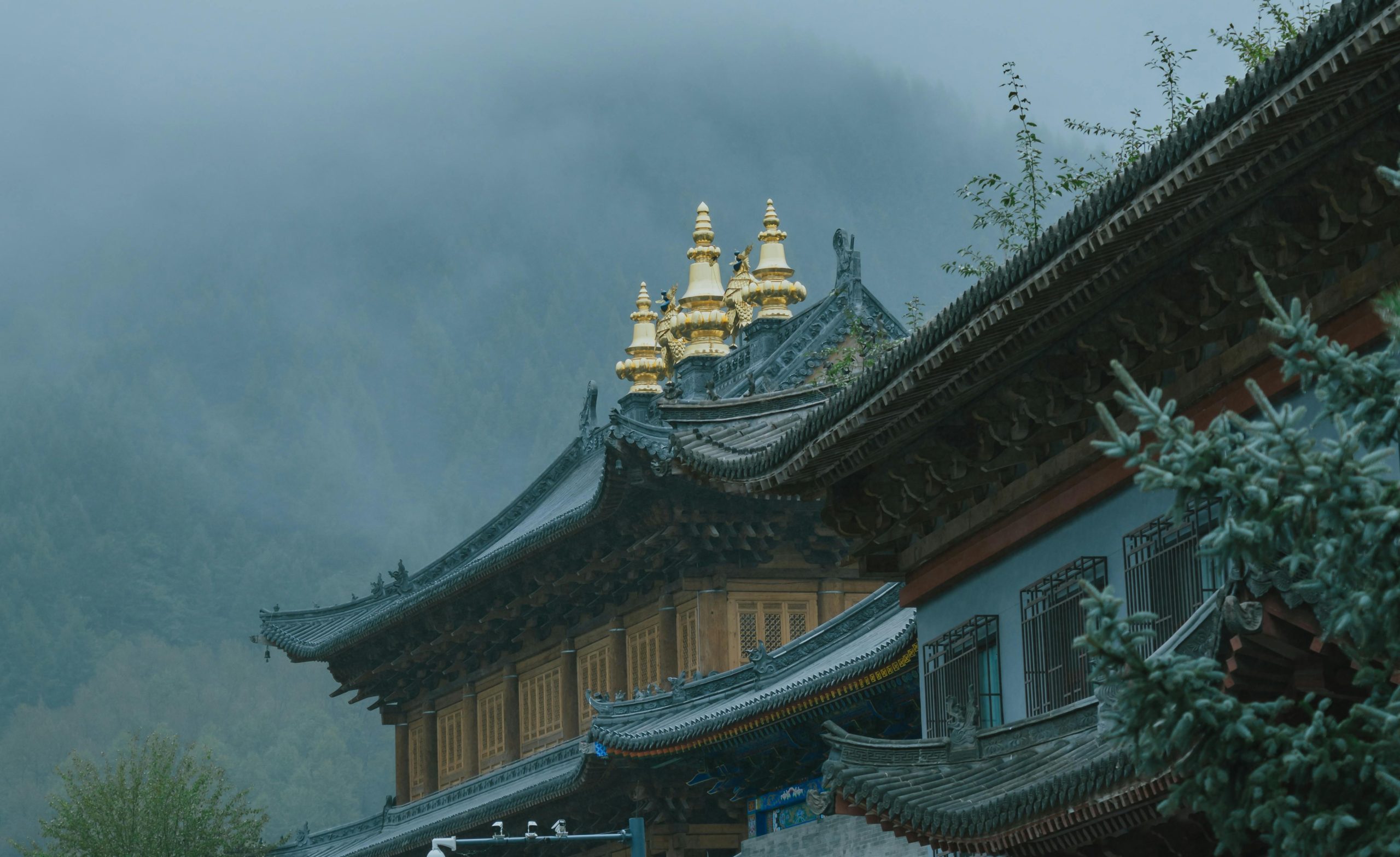 A beautiful temple with ornate roofs set against misty mountains, exuding serenity and spirituality.