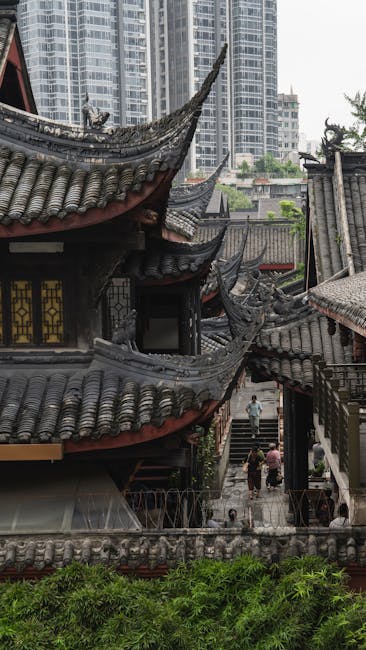 Traditional Chinese temple architecture amidst modern city buildings in Chengdu, China.